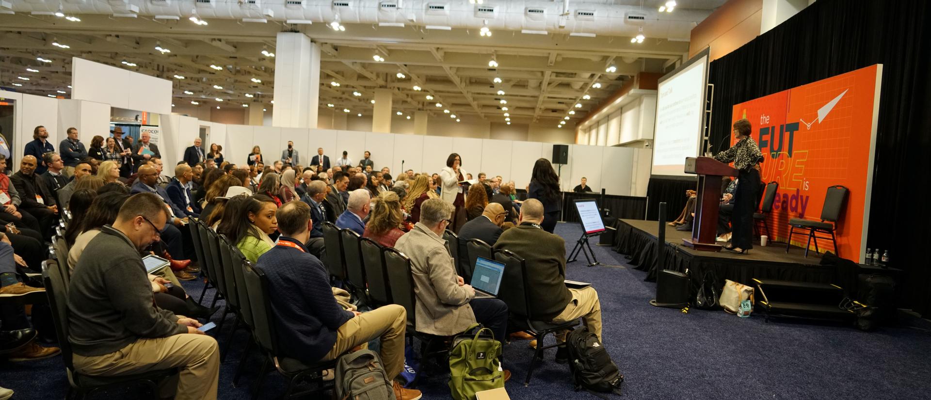 A wide angle view of a room at a conference.